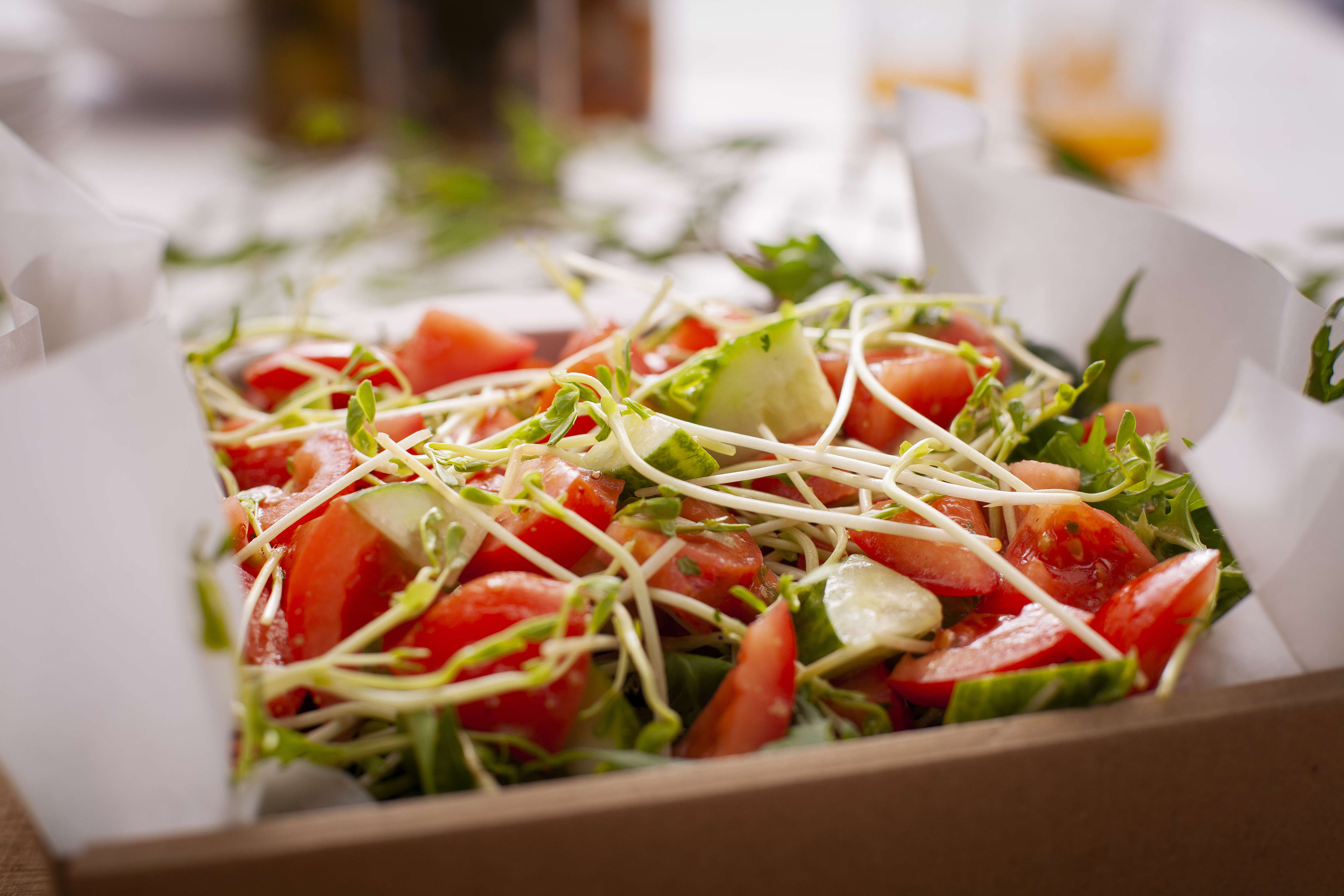 Garden salad catering box including lettuce, tomato, cucumber, and vinaigrette dressing. Photo: Richard Jupe.