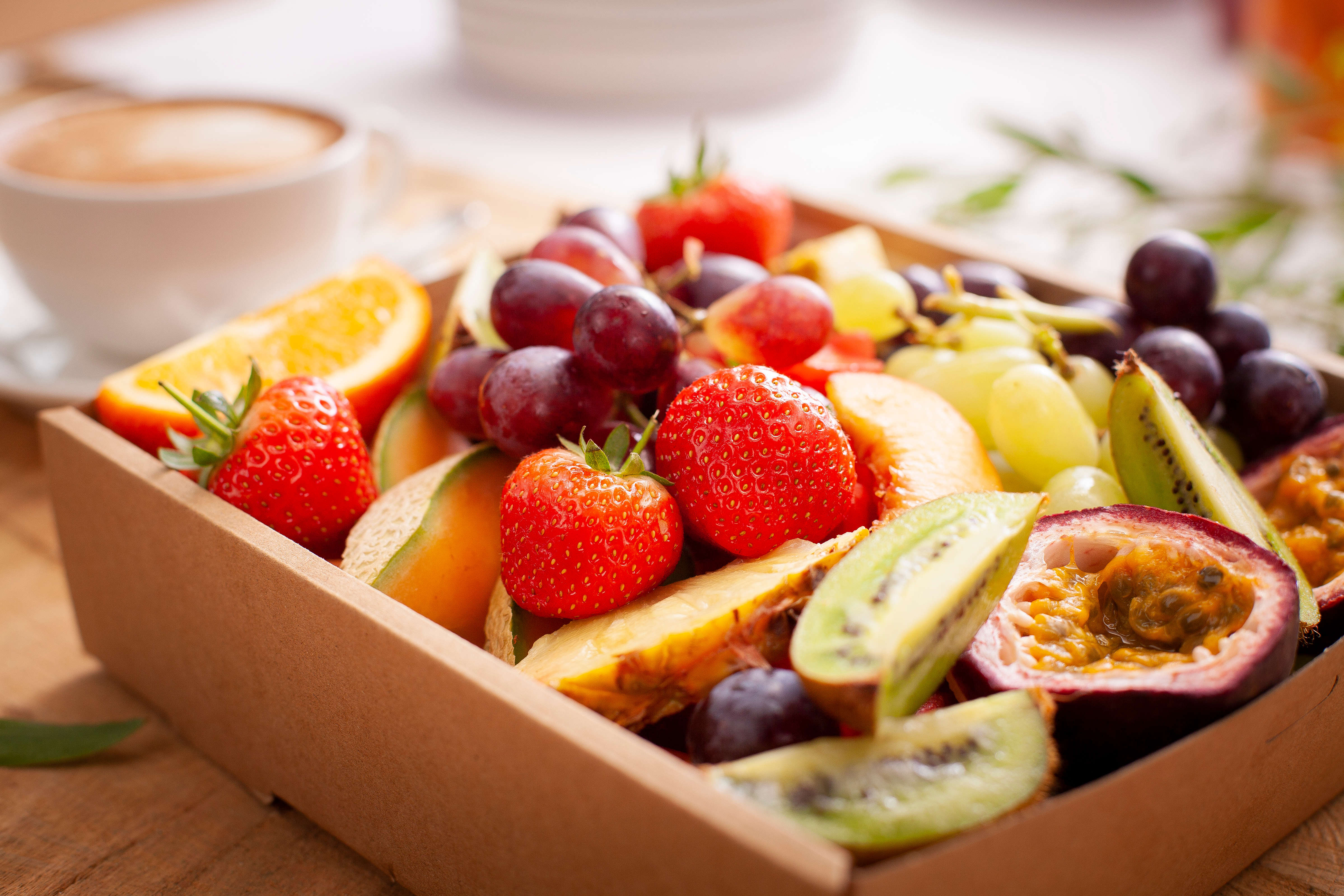 Close uo of Fresh seasonal fruit catering box. Box pictured includes orange wedges, strawberries, red and green grapes, passionfruit halves, kiwifruit wedges, peach slices pineapple slices, and rockmelon pieces. Photo: Richard Jupe.