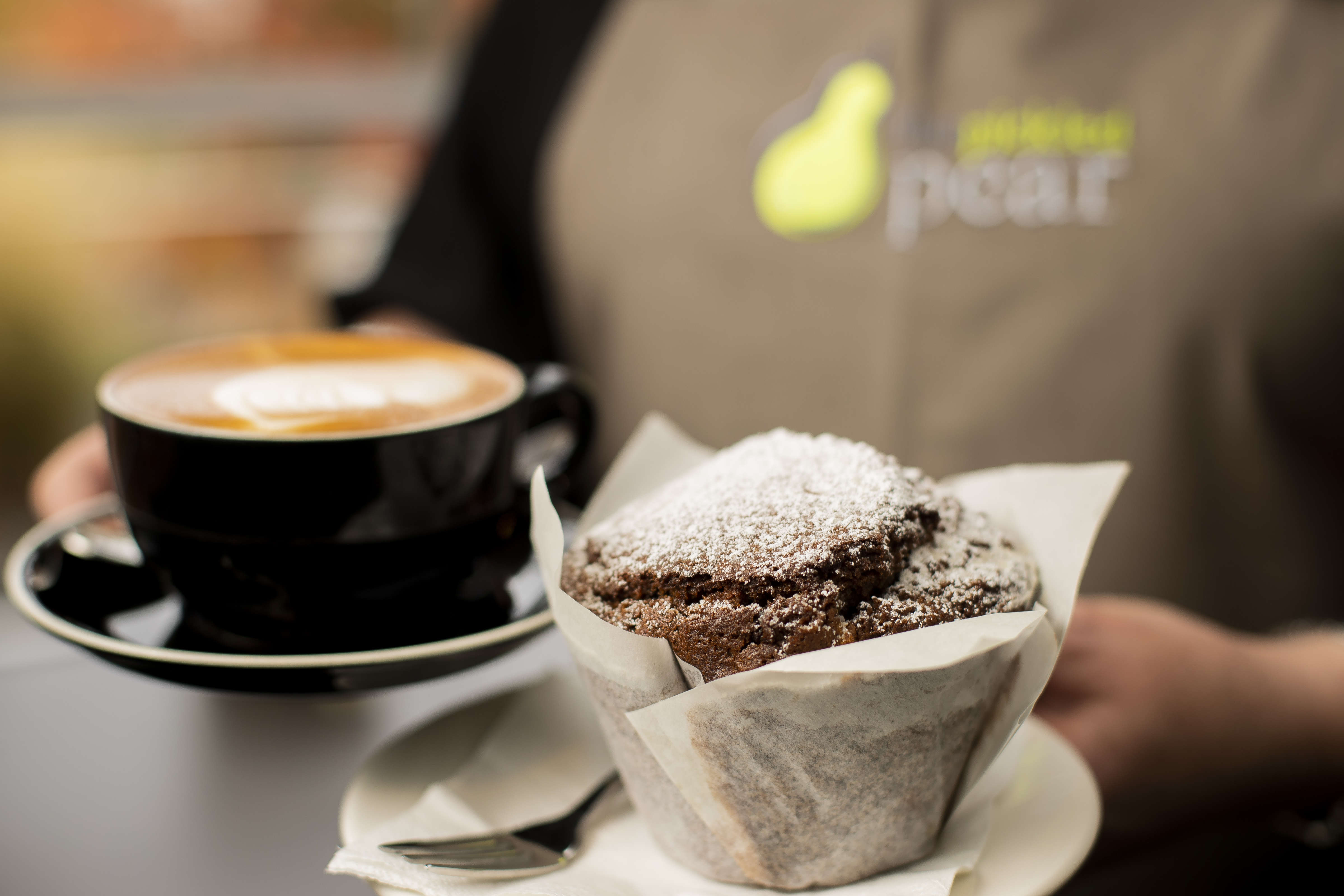 Close up of a flat white and a chocolate muffin being served. Photo: Richard Jupe.
