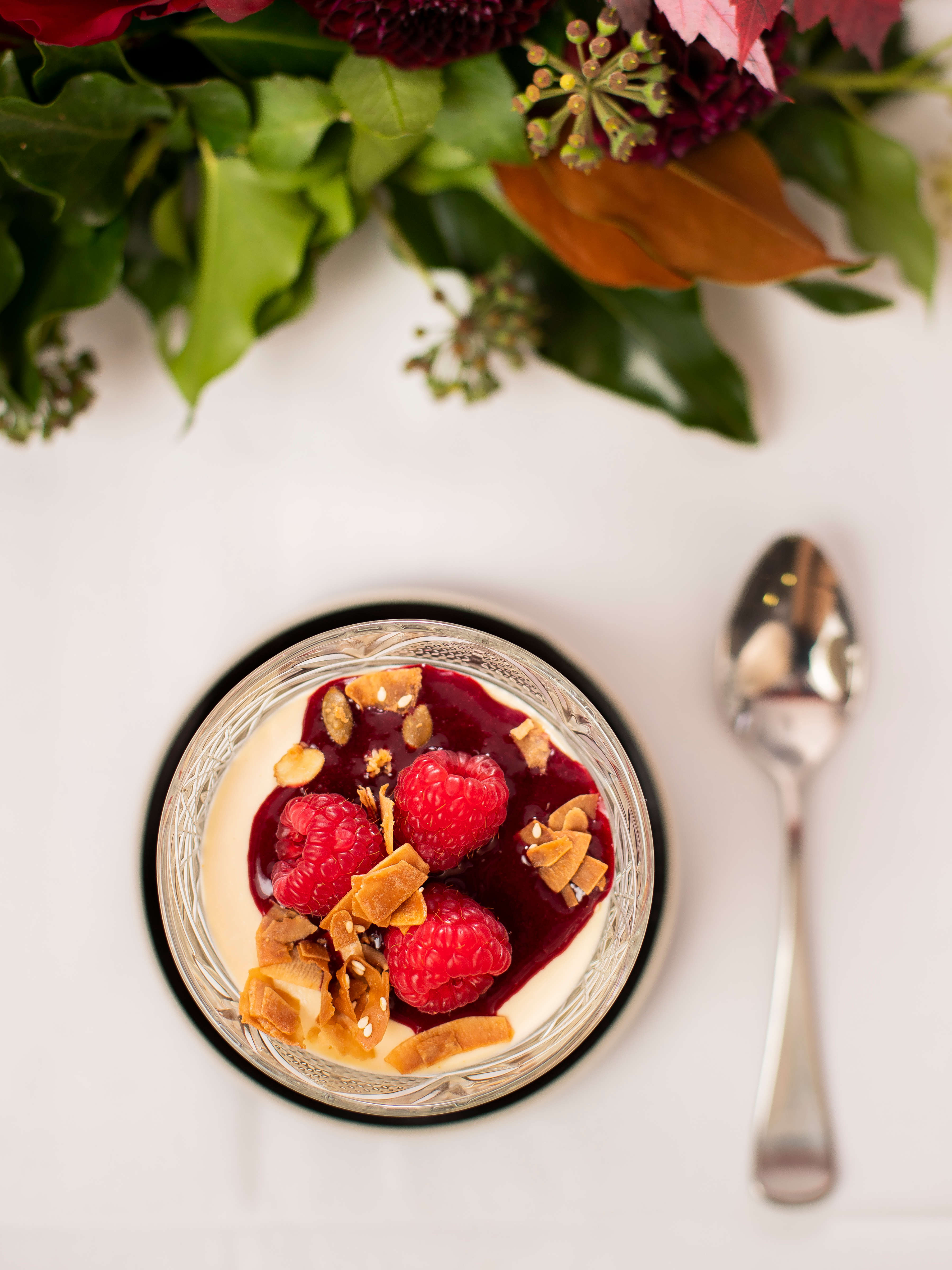 Flat lay photo of Vanilla panna cotta with raspberry coulis and fresh raspberries. Photo: Richard Jupe.