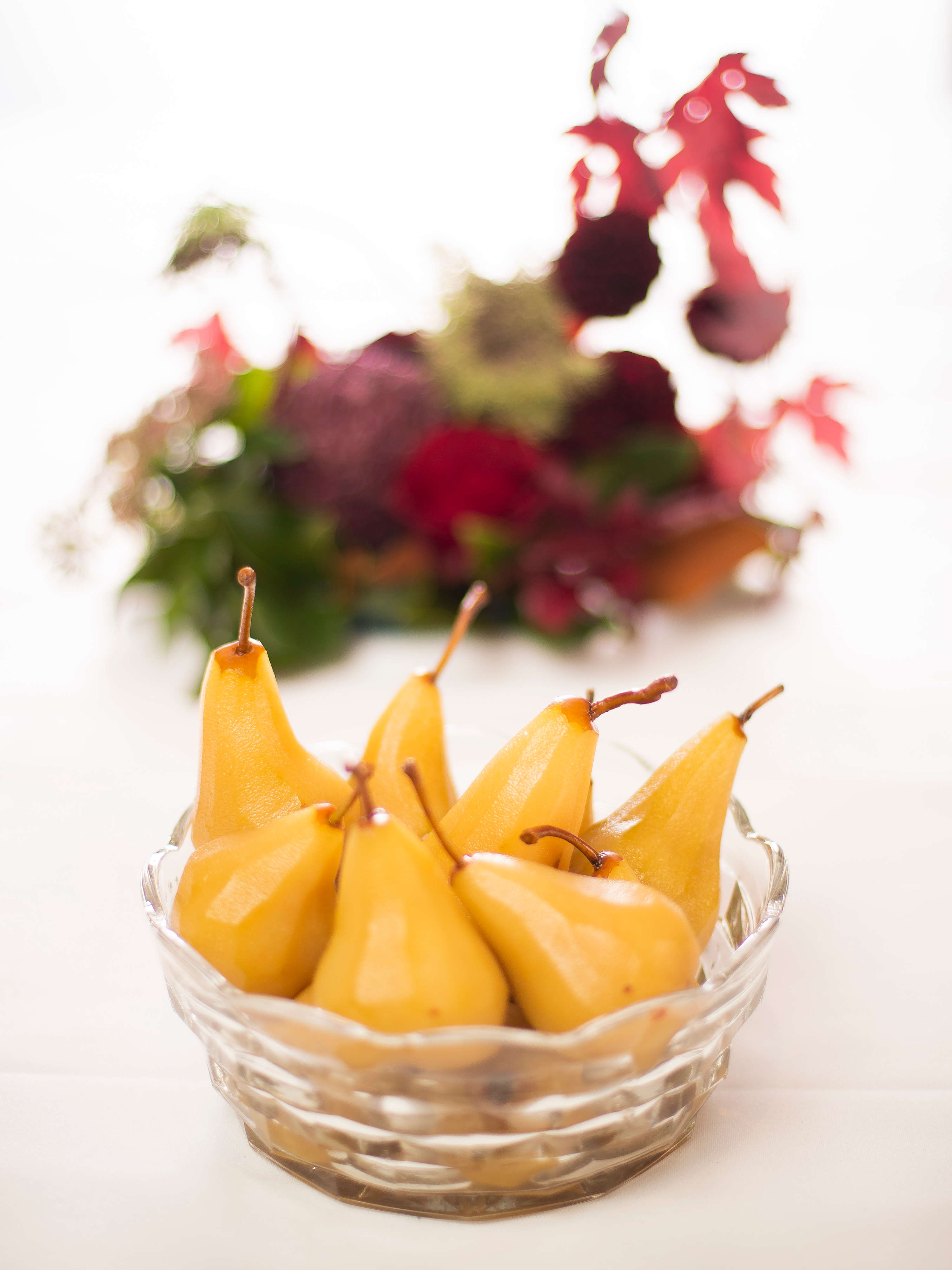 Seven pears that have been poached in saffron syrup in a cut glass bowl. Photo: Richard Jupe.